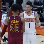 Phoenix Suns guard Devin Booker (1) greets Cleveland Cavaliers guard Isaac Okoro (35) after an NBA basketball game, Monday, Feb. 8, 2021, in Phoenix. (AP Photo/Matt York)