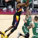 Phoenix Suns forward Mikal Bridges, left, shoots over the defense of Boston Celtics guard Payton Pritchard (11) and forward Daniel Theis during the first half of an NBA basketball game, Sunday, Feb. 7, 2021, in Phoenix. (AP Photo/Ralph Freso)
