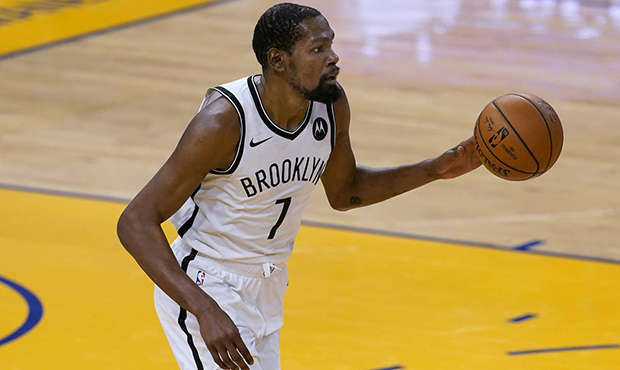 Brooklyn Nets forward Kevin Durant brings the ball up against the Golden State Warriors during the ...