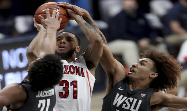 Arizona guard Terrell Brown Jr. (31) gets squeezed into a miss by Washington State center Dishon Ja...