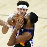 Phoenix Suns forward Mikal Bridges battles Philadelphia 76ers guard Seth Curry, rear, for the ball during the second half of an NBA basketball game, Saturday, Feb. 13, 2021, in Phoenix.(AP Photo/Matt York)