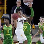 Arizona State guard Remy Martin (1) looks to pass as Oregon center Franck Kepnang (22) and guard Amauri Hardy (11) defend during the first half of an NCAA college basketball basketball game, Thursday, Feb. 11, 2021, in Tempe, Ariz. (AP Photo/Matt York)