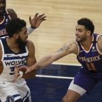 Minnesota Timberwolves's Karl-Anthony Towns (32) tries to maintain control of the ball against Phoenix Suns' Abdel Nader (11) in the first half of an NBA basketball game Sunday, Feb. 28, 2021, in Minneapolis. (AP Photo/Stacy Bengs)