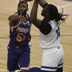 Minnesota Timberwolves's Naz Reid (11) goes after the ball against Phoenix Suns' E'Twaun Moore (55) in the first half of an NBA basketball game Sunday, Feb. 28, 2021, in Minneapolis. (AP Photo/Stacy Bengs)