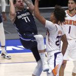 Dallas Mavericks guard Luka Doncic (77) is jammed up by Phoenix Suns forward Cameron Johnson (23) while trying to shoot in the second half during an NBA basketball game, Monday, Feb. 1, 2021, in Dallas. (AP Photo/ Richard W. Rodriguez)