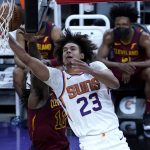 Phoenix Suns forward Cameron Johnson (23) shoots past Cleveland Cavaliers forward Taurean Prince (12) during the second half of an NBA basketball game, Monday, Feb. 8, 2021, in Phoenix. (AP Photo/Matt York)