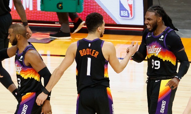 Jae Crowder #99 and Devin Booker #1 of the Phoenix Suns celebrate after defeating the Milwaukee Buc...