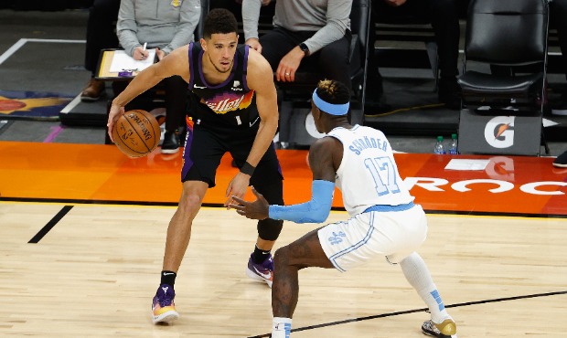 Devin Booker #1 of the Phoenix Suns handles the ball against Dennis Schroder #17 of the Los Angeles...