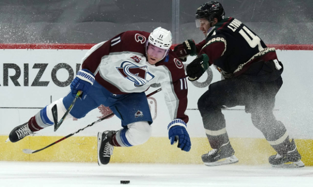 Colorado Avalanche left wing Matt Calvert gets knocked off his skates while fighting for the puck a...