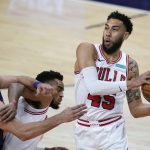 Chicago Bulls guard Denzel Valentine, right, grabs a rebound as Phoenix Suns forward Dario Saric, left, and Bulls forward Troy Brown Jr., middle, battle for position during the first half of an NBA basketball game Wednesday, March 31, 2021, in Phoenix. (AP Photo/Ross D. Franklin)
