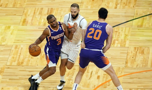 Orlando Magic guard Evan Fournier, center, fouls Phoenix Suns guard Chris Paul (3) as he gets caugh...