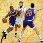 Orlando Magic guard Evan Fournier, center, fouls Phoenix Suns guard Chris Paul (3) as he gets caught in a pick by Phoenix Suns forward Dario Saric (20) during the second half of an NBA basketball game, Wednesday, March 24, 2021, in Orlando, Fla. (AP Photo/John Raoux)