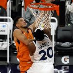 Phoenix Suns guard Devin Booker, left, shoots over Minnesota Timberwolves forward Josh Okogie (20) during the second half of an NBA basketball game Friday, March 19, 2021, in Phoenix. Phoenix won 113-101. (AP Photo/Rick Scuteri)