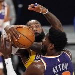 Los Angeles Lakers forward LeBron James, left, blocks the shot of Phoenix Suns center Deandre Ayton during the first half of an NBA basketball game Tuesday, March 2, 2021, in Los Angeles. (AP Photo/Mark J. Terrill)