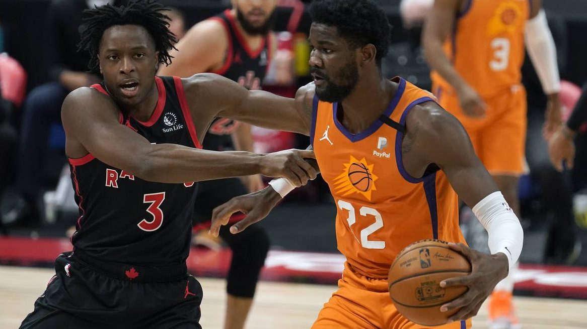 Toronto Raptors forward OG Anunoby (3) holds Phoenix Suns center Deandre Ayton (22) as he attempts ...