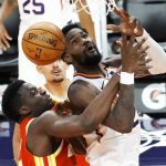 Phoenix Suns center Deandre Ayton, right, gets fouled by Atlanta Hawks center Clint Capela during the second half of an NBA basketball game, Tuesday, March 30, 2021, in Phoenix. Phoenix won 117-110. (AP Photo/Rick Scuteri)