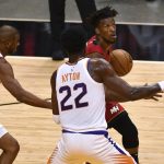 Miami Heat forward Jimmy Butler (22) drives to the basket as Phoenix Suns guard Chris Paul (3) and center Deandre Ayton (22) defend during the first half of an NBA basketball game Tuesday, March. 23, 2021, in Miami. (AP Photo/Jim Rassol)