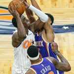 Orlando Magic guard Dwayne Bacon, left, goes up for a shot against Phoenix Suns guard Cameron Payne, right, and forward Torrey Craig (12) during the first half of an NBA basketball game, Wednesday, March 24, 2021, in Orlando, Fla. (AP Photo/John Raoux)