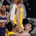 Los Angeles Lakers forward Markieff Morris, left, blocks the shot of Phoenix Suns forward Dario Saric during the first half of an NBA basketball game Tuesday, March 2, 2021, in Los Angeles. (AP Photo/Mark J. Terrill)