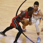 Phoenix Suns guard Devin Booker (1) defends against Miami Heat guard Kendrick Nunn during the first half of an NBA basketball game Tuesday, March 23, 2021, in Miami. (AP Photo/Jim Rassol)
