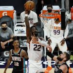 Phoenix Suns center Deandre Ayton (22) shoots over Memphis Grizzlies guard Ja Morant (12) and forward Kyle Anderson during the first half of an NBA basketball game Monday, March 15, 2021, in Phoenix. (AP Photo/Rick Scuteri)