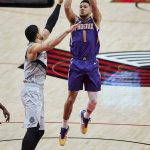 Phoenix Suns guard Devin Booker, right, shoots over Portland Trail Blazers center Enes Kanter during the first half of an NBA basketball game in Portland, Ore., Thursday, March 11, 2021. (AP Photo/Craig Mitchelldyer)