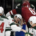 Minnesota Wild's Carson Soucy, center, fights with Arizona Coyotes' Lawson Crouse (67) during the first period of an NHL hockey game Tuesday, March 16, 2021, in St. Paul, Minn. Both players received penalties. (AP Photo/Hannah Foslien)