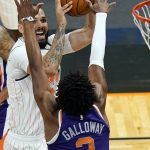 Orlando Magic guard Evan Fournier, left, takes a shot over Phoenix Suns guard Langston Galloway (2) during the first half of an NBA basketball game, Wednesday, March 24, 2021, in Orlando, Fla. (AP Photo/John Raoux)