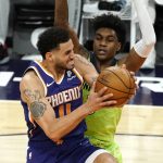 Phoenix Suns forward Abdel Nader (11) drives on Minnesota Timberwolves forward Jaden McDaniels during the second half of an NBA basketball game Thursday, March 18, 2021, in Phoenix. Minnesota won 123-119. (AP Photo/Rick Scuteri)