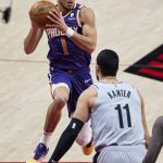 
              Phoenix Suns guard Devin Booker, left, drives to the basket in front of Portland Trail Blazers center Enes Kanter during the first half of an NBA basketball game in Portland, Ore., Thursday, March 11, 2021. (AP Photo/Craig Mitchelldyer)
            