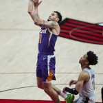 Phoenix Suns forward Abdel Nader, left, shoots over Portland Trail Blazers guard Anfernee Simons during the first half of an NBA basketball game in Portland, Ore., Thursday, March 11, 2021. (AP Photo/Craig Mitchelldyer)