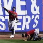 Arizona Diamondbacks center fielder Ketel Marte, right, ducks as right fielder Tim Locastro (16) throws in a ball hit by Milwaukee Brewers' Christian Yelich during the first inning of a spring training baseball game Friday, March 19, 2021, in Phoenix. (AP Photo/Ashley Landis)