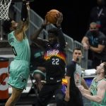 Phoenix Suns center Deandre Ayton shoots between Charlotte Hornets forward Miles Bridges, left, and forward Gordon Hayward during the first half of an NBA basketball game on Sunday, March 28, 2021, in Charlotte, N.C. (AP Photo/Chris Carlson)
