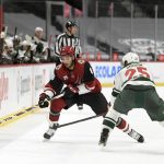 Arizona Coyotes' Nick Schmaltz (8) passes the puck past Minnesota Wild's Jonas Brodin (25) during the second period of an NHL hockey game Tuesday, March 16, 2021, in St. Paul, Minn. (AP Photo/Hannah Foslien)