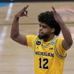 Michigan guard Mike Smith celebrates after making a 3-point basket during the second half of an Elite 8 game against UCLA in the NCAA men's college basketball tournament at Lucas Oil Stadium, Tuesday, March 30, 2021, in Indianapolis. (AP Photo/Michael Conroy)