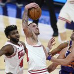 Chicago Bulls center Daniel Theis, middle, pulls down a rebound as Phoenix Suns forward Dario Saric, right, and Bulls forward Patrick Williams, left, are unable to get the ball during the second half of an NBA basketball game Wednesday, March 31, 2021, in Phoenix. The Suns won 121-116. (AP Photo/Ross D. Franklin)
