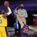 Los Angeles Lakers forward LeBron James, left, shoots as Phoenix Suns forward Dario Saric defends during the first half of an NBA basketball game Tuesday, March 2, 2021, in Los Angeles. (AP Photo/Mark J. Terrill)