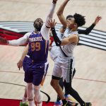 Portland Trail Blazers guard Anfernee Simons, right, shoots over Phoenix Suns forward Jae Crowder during the second half of an NBA basketball game in Portland, Ore., Thursday, March 11, 2021. (AP Photo/Craig Mitchelldyer)