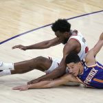 Phoenix Suns guard Devin Booker (1) and Chicago Bulls forward Thaddeus Young scramble for the ball during the second half of an NBA basketball game Wednesday, March 31, 2021, in Phoenix. (AP Photo/Ross D. Franklin)