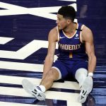 Phoenix Suns guard Devin Booker watches as play continues after he was knocked to the floor during the second half of the team's NBA basketball game against the Golden State Warriors on Thursday, March 4, 2021, in Phoenix. (AP Photo/Rick Scuteri)