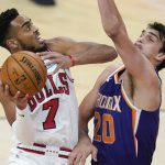 Chicago Bulls forward Troy Brown Jr. (7) tries to get off a shot over Phoenix Suns forward Dario Saric (20) during the second half of an NBA basketball game Wednesday, March 31, 2021, in Phoenix. The Suns won 121-116. (AP Photo/Ross D. Franklin)