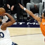 Minnesota Timberwolves forward Josh Okogie, left, shoots in front of Phoenix Suns guard Devin Booker (1) during the first half of an NBA basketball game Friday, March 19, 2021, in Phoenix. (AP Photo/Rick Scuteri)