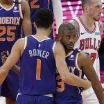 Phoenix Suns guard Chris Paul (3) gets a hug from guard Devin Booker (1) as Chicago Bulls center Daniel Theis, back right, walks past after Paul scored and was fouled during the second half of an NBA basketball game Wednesday, March 31, 2021, in Phoenix. The Suns won 121-116. (AP Photo/Ross D. Franklin)