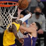 Phoenix Suns guard Devin Booker, right, is fouled in the act of shooting by Los Angeles Lakers guard Dennis Schroder during the first half of an NBA basketball game Tuesday, March 2, 2021, in Los Angeles. (AP Photo/Mark J. Terrill)