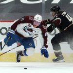 Colorado Avalanche left wing Matt Calvert gets knocked off his skates while fighting for the puck against Arizona Coyotes defenseman Niklas Hjalmarsson (4) during the first period during an NHL hockey game, Monday, March 22, 2021, in Glendale, Ariz. (AP Photo/Rick Scuteri)