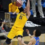 Michigan forward Austin Davis (51) dunks the ball over UCLA guard Jules Bernard (1) during the second half of an Elite 8 game in the NCAA men's college basketball tournament at Lucas Oil Stadium, Tuesday, March 30, 2021, in Indianapolis. (AP Photo/Darron Cummings)