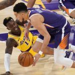 Los Angeles Lakers guard Dennis Schroder, left, loses control of the ball as Phoenix Suns guard Devin Booker takes it during the first half of an NBA basketball game Tuesday, March 2, 2021, in Los Angeles. (AP Photo/Mark J. Terrill)