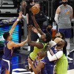 Minnesota Timberwolves forward Anthony Edwards (1) drives between Phoenix Suns guard Devin Booker, left, guard Chris Paul and forward Jae Crowder, right, during the second half of an NBA basketball game Thursday, March 18, 2021, in Phoenix. Minnesota won 123-119. (AP Photo/Rick Scuteri)