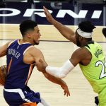 Minnesota Timberwolves forward Josh Okogie fouls Phoenix Suns guard Devin Booker (1) during the second half of an NBA basketball game Thursday, March 18, 2021, in Phoenix. Minnesota won 123-119. (AP Photo/Rick Scuteri)