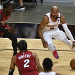 Phoenix Suns guard Jevon Carter (4) drives to the basket as Miami Heat guards Kendrick Nunn, left, and Gabe Vincent (2) defend during the second half of an NBA basketball game Tuesday, March 23, 2021, in Miami. (AP Photo/Jim Rassol)